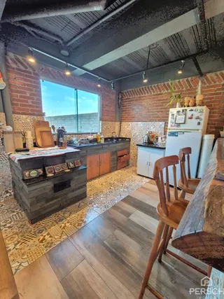 Cozinha com bancada de madeira e piso de cerâmica em um imóvel.