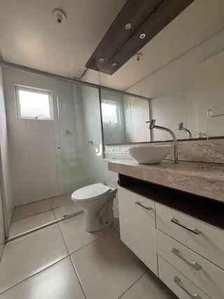 Banheiro moderno com piso de cerâmica e box de vidro.