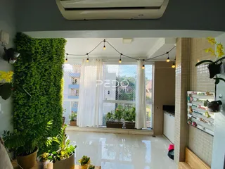 Sala de estar com jardim vertical e grandes janelas em um imóvel no Brasil.