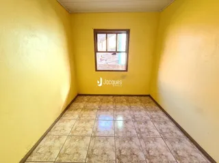 Foto de uma sala com paredes amarelas e piso de cerâmica.