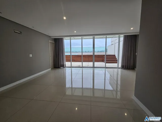 Ambiente interno amplo com piso de cerâmica e porta de vidro que dá para uma área externa.