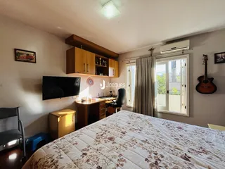 Quarto com cama grande e televisão em um apartamento no Brasil.