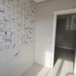 Parede interna revestida com azulejos brancos na propriedade.