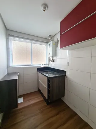 Interior de um ambiente com piso de madeira e janela.