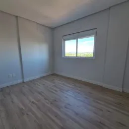 Foto de um ambiente interno com piso de madeira e janela.