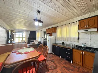 Interior de uma sala de estar com piso de tijolo e detalhes de parede de tijolo aparente.