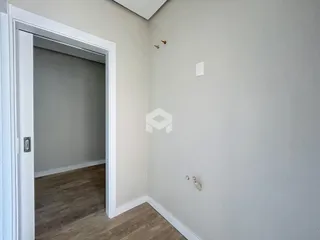 Vista de um corredor interno com porta aberta em uma residência.
