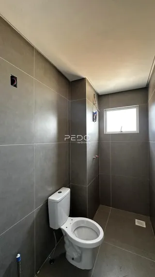 Foto de um banheiro com paredes revestidas em cinza.
