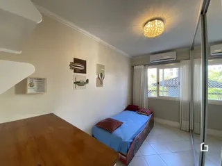 Quarto interno com cama e parede clara em uma residência.