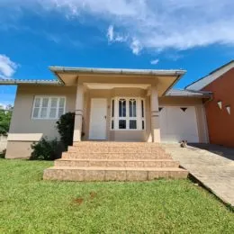Fachada de uma residência em Lajeado, Brasil, com jardim frontal e entrada coberta.