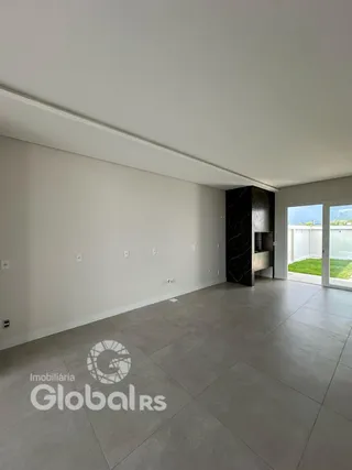 Espaço interno de uma residência com paredes brancas e piso cinza.