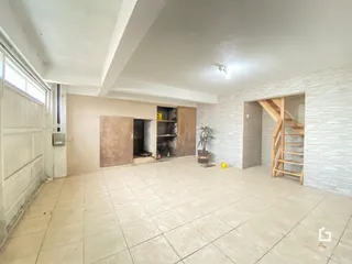Ambiente interno com piso de cerâmica e escadaria de madeira.