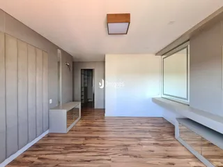 Ambiente interno com piso de madeira e paredes cinzas.