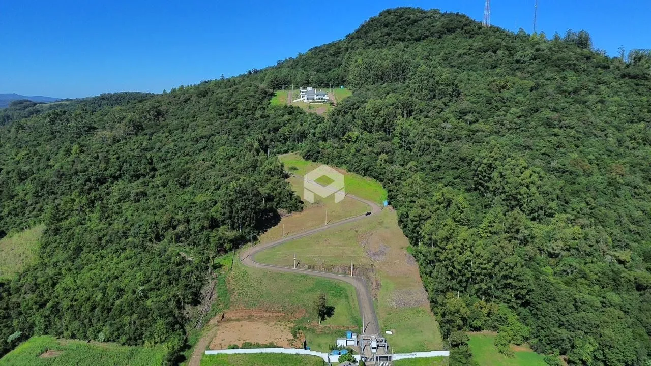 Vista aérea de uma propriedade cercada por densa floresta.