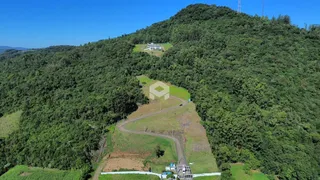 Vista aérea de uma propriedade cercada por densa floresta.