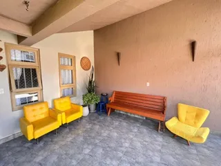 Sala de estar com assentos amarelos e um banco de madeira.