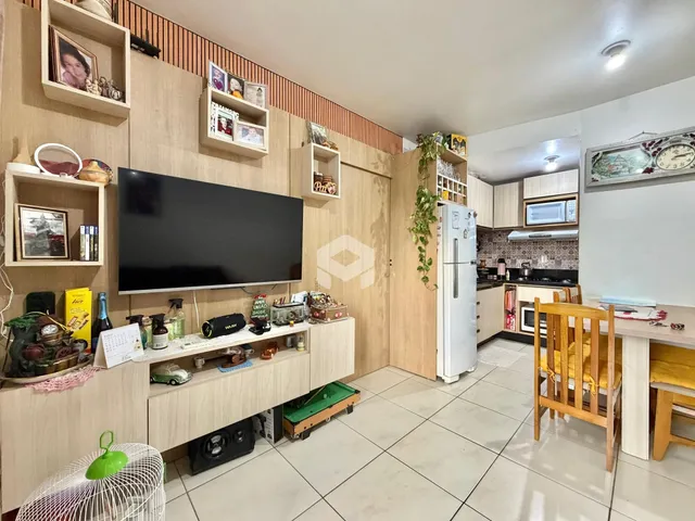 Sala de estar com decoração de madeira e televisão em um apartamento no Brasil.