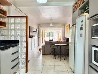 Interior de uma sala de estar com piso de cerâmica e portas de vidro.
