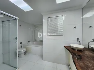 Banheiro com piso de cerâmica e box de vidro.