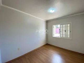 Ambiente interno com piso de madeira e paredes brancas.