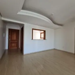 Ambiente interno com piso de madeira clara e paredes brancas.