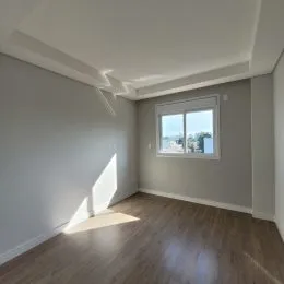 Ambiente interno com piso de madeira e janela mostrando a vista externa.