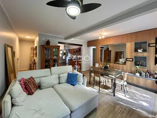 Sala de estar com sofá branco e decoração de madeira.