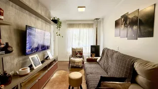 Sala de estar com sofá e televisão em um ambiente claro.