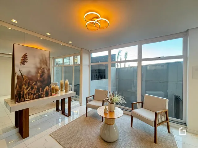 Sala de estar com grandes janelas que oferecem uma vista externa.