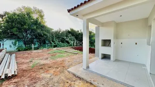 Vista da fachada de uma residência em construção com área externa de terra.