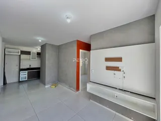 Ambiente interno de uma sala com paredes em construção e piso de cerâmica.