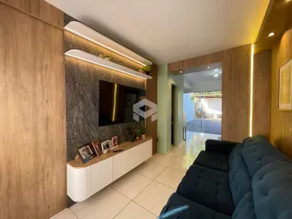 Uma sala de estar moderna com painéis de madeira e parede de pedra escura.