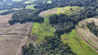 Vista aérea de uma paisagem rural com campos e vegetação densa.