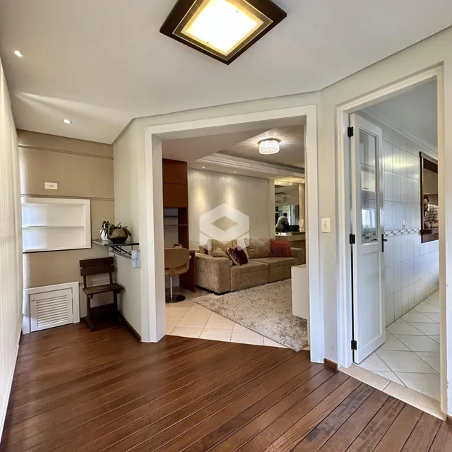 Hall de entrada com piso de madeira e vista para a sala de estar.