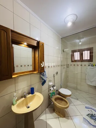 Foto de um banheiro com piso de cerâmica e box de vidro.