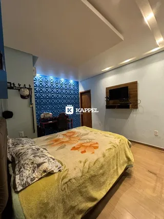 Quarto com cama e piso de madeira em um imóvel.