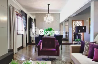 Sala de estar com piso de madeira e cortinas escuras.