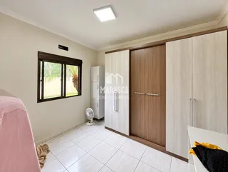 Quarto com janela e armário de madeira em um imóvel em Lajeado.