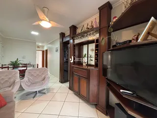 Sala de estar com decoração de madeira e sofá claro.