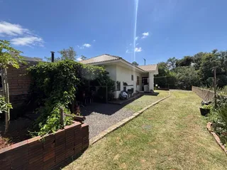 Foto da fachada de uma casa com jardim e área externa em Lajeado.