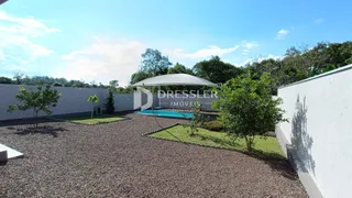 Vista externa de um jardim com piscina e área de gramado em Lajeado.