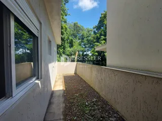 Vista lateral de um terreno com caminho de concreto entre duas edificações.