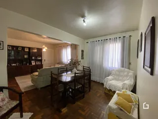 Sala de jantar com piso de madeira e sofá na residência.