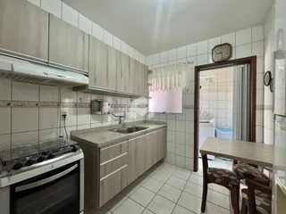 Foto da cozinha com armários e revestimento de cerâmica em Lajeado.