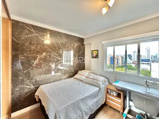 Quarto com parede de mármore e vista da cidade.
