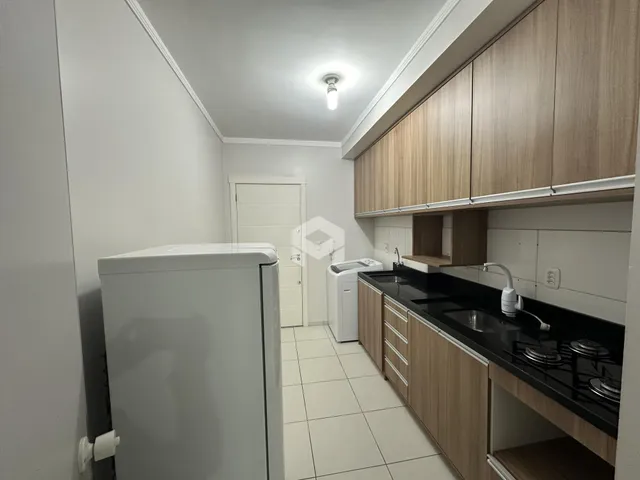 Vista interna de uma cozinha com armários de madeira e piso cerâmico.