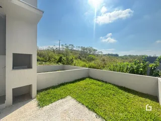 Fachada de uma residência com jardim e vista para a vegetação.