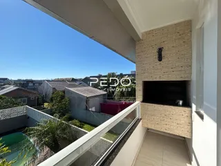 Vista de um imóvel com varanda e céu azul.