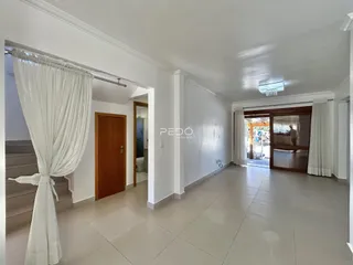 Hall de entrada com piso de cerâmica e paredes brancas em uma residência.