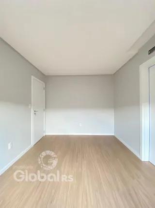 Ambiente interno de uma sala com piso de madeira clara.